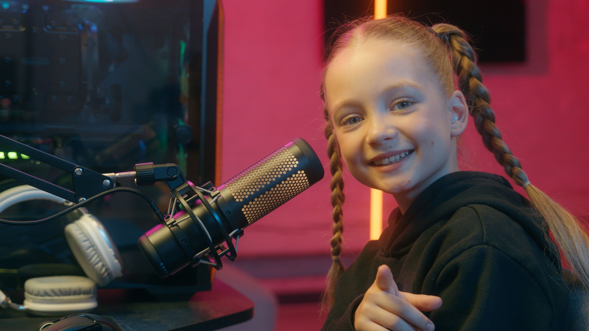 Caucasian little teen girl daughter child kid streamer gamer influencer gen z video internet game computer addiction at night radio stream showing pointing index finger at camera smiling hey you look