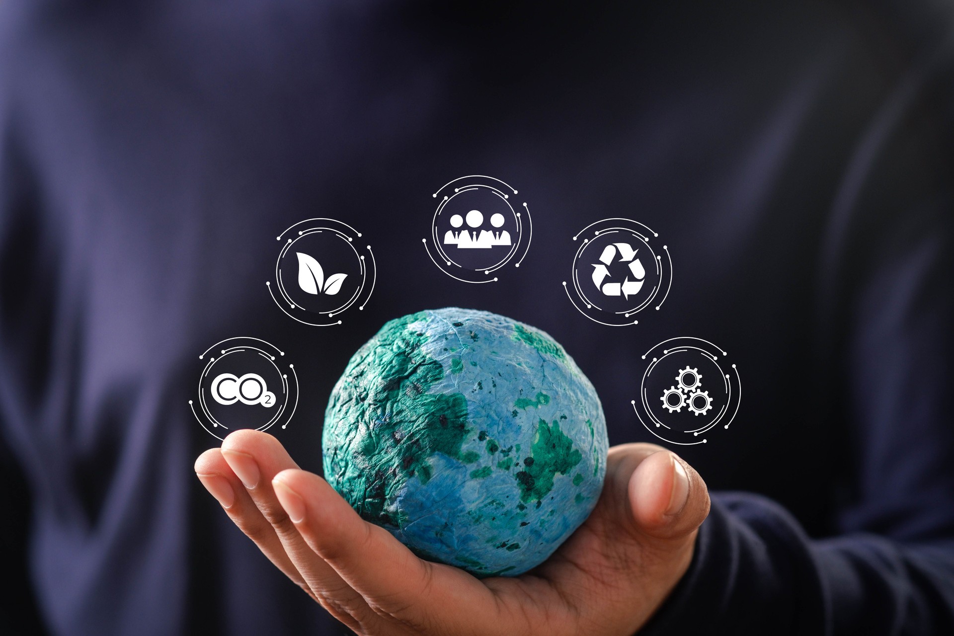 A person holds a globe symbolizing environmental awareness and sustainability, surrounded by eco-friendly icons.